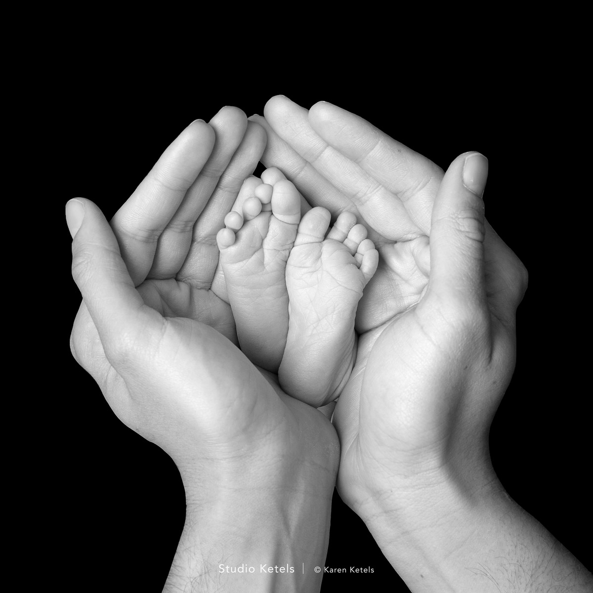 Close-up van babyvoetjes in papa zijn handen door Studio Ketels